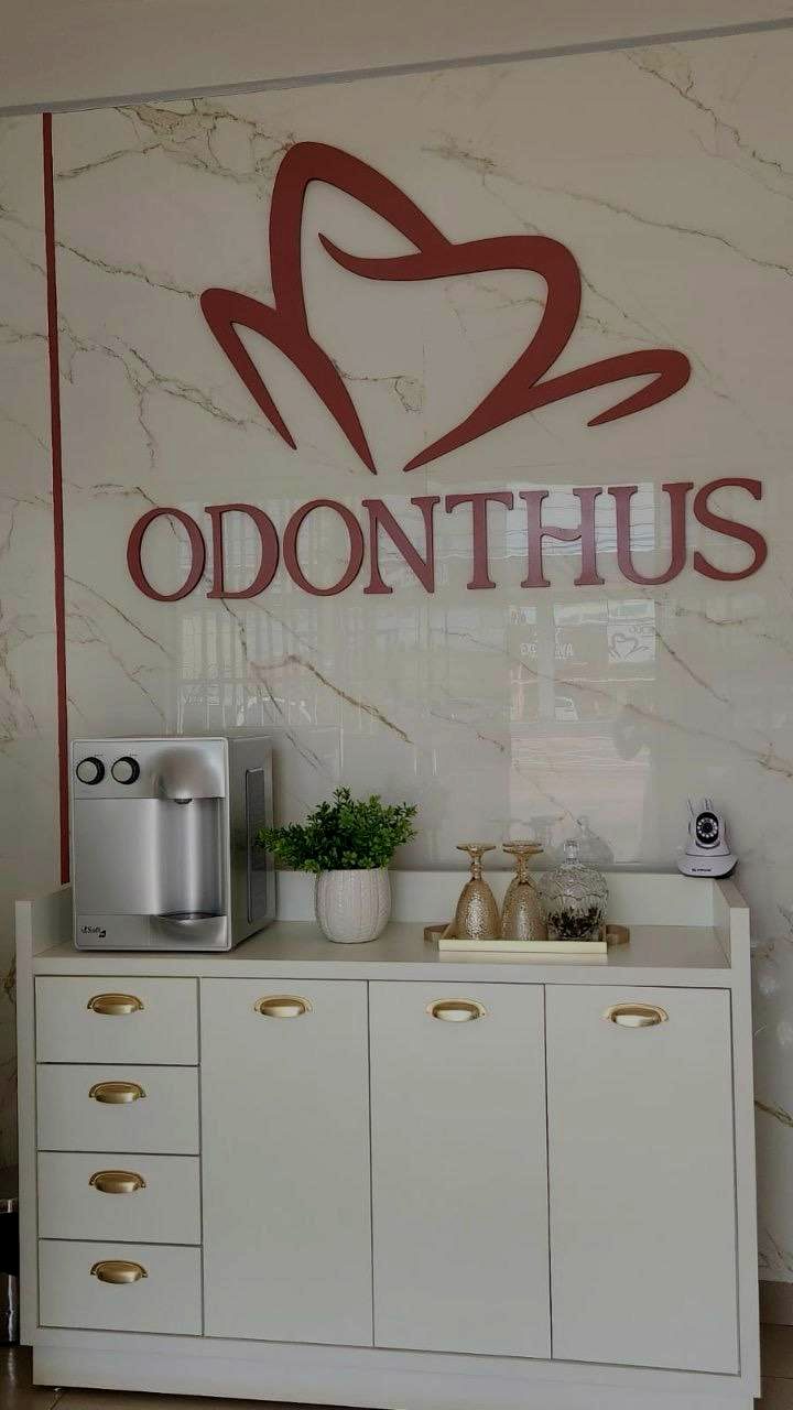 Recepção da Odonthus, com o logo na parede de mármore